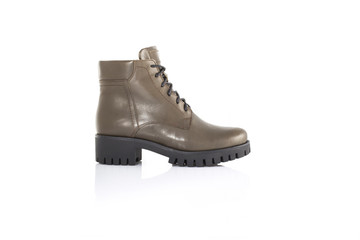 Close up of a gren women boots shoes on white background with reflection. Fashion advertising shoes...