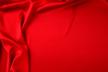 Red silk or satin luxury fabric texture can use as abstract background. Top view.