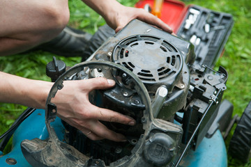 men's hands and gasoline engine repair close-up
