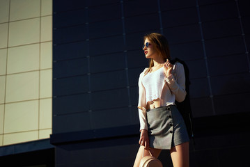 A girl in stylish clothes is walking in the city. Street fashion, style, casual clothes. Freedom, youth, beauty
