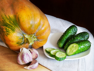 Still life with pumpkin, garlic and cucumber
