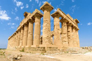 Obraz premium Ruins of the doric Temple of Hera (Temple E) inside the archaeological park of Selinunte, an ancient Greek city on a seaside hill in the south west coast of Sicily.