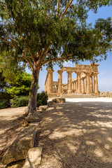 Obraz premium Ruins of the doric Temple of Hera (Temple E) inside the archaeological park of Selinunte, an ancient Greek city on a seaside hill in the south west coast of Sicily.
