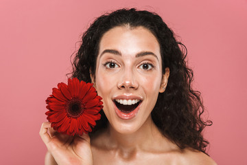 Beauty photo of half naked woman with long hair and no makeup holding red flower, isolated over...
