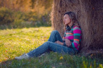 a girl near a haystack