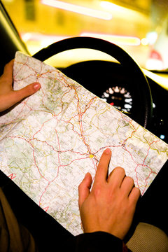 Crop driver in car pointing on map