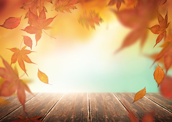 Herfst seizoen achtergrond met vallende boombladeren en een houten tafel.