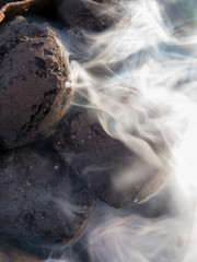 Kohle Briketts werden angezündet und entwickeln starken weißen Rauch