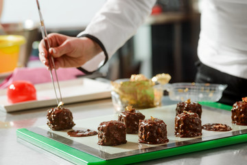 Placing decorations with kitchen tongs