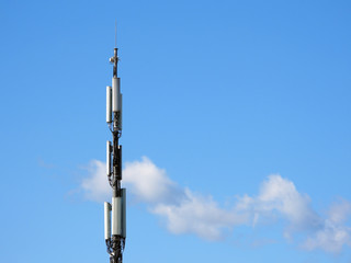 Obraz premium Cellular tower on the blue sky with some clouds background