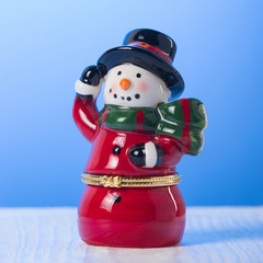 christmas decoration snowman in a red coat, on a blue background, christmas concept