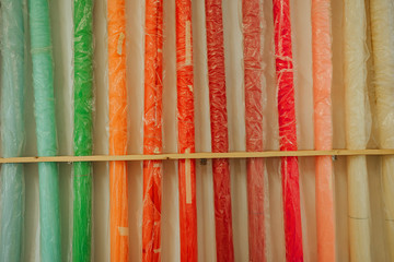 Colorful paper backgrounds for a photo studio in the polyethylene near the wall. New paper backgrounds. Photo studio environment. Red, orange and rainbow color