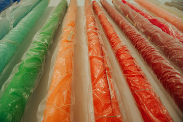 Colorful paper backgrounds for a photo studio in the polyethylene near the wall. New paper...