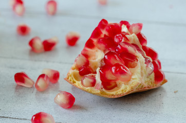 Sliced pomegranate and grains on wooden table,