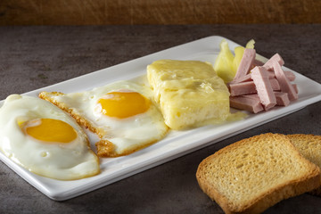 Fried eggs with melted Romanian cheese called cas and some parizer