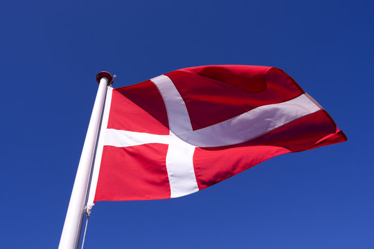 Flags / Laesoe / Denmark: The Danish national flag &bdquo;Dannebrog&ldquo; is fluttering in the gusty coastal wind on Laesoe island