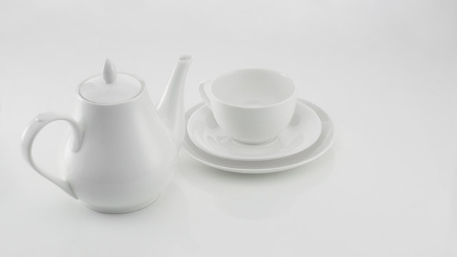 white ceramic teapot with cup on light background