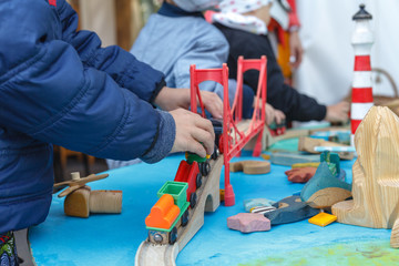 autistic boy playing with toy car on wooden table