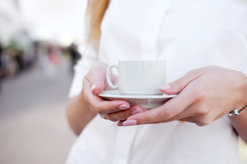 holding cup of coffee in the open air place or observation deck. Old town on background. Concept love morning.