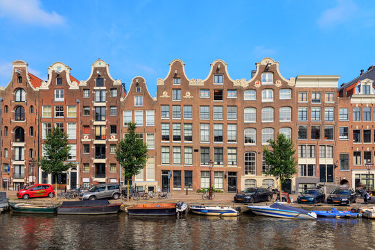 Beautiful view of the canal houses at the Prinsengracht canal in Amsterdam, the Netherlands, on a summer day with blue sky
