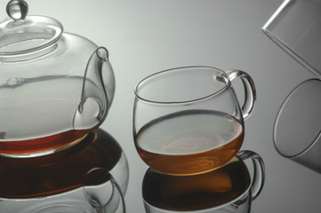 transparent glass teapot and tea cup with reflection