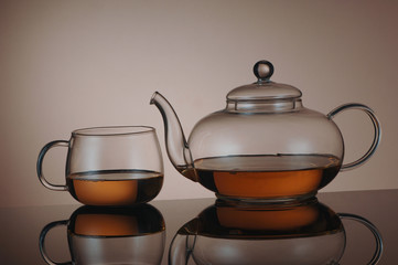 transparent glass teapot and tea cup with reflection
