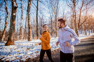 Fitness couple winter morning exercise at snowy mountain.