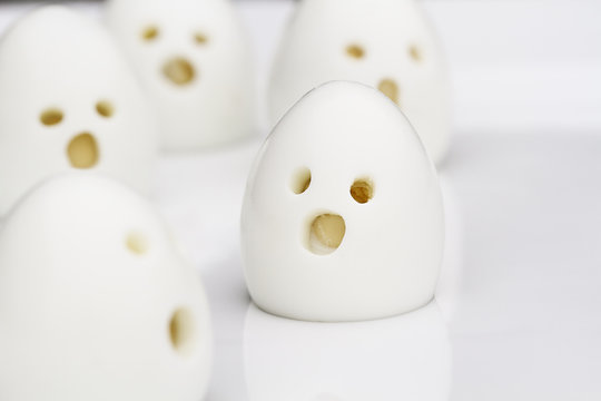 Fun food for kids. Party foods of hard boiled ghost ghoul eggs perfect for Halloween. Alternative to candy. Shallow depth of field with selective focus on egg in center of plate.