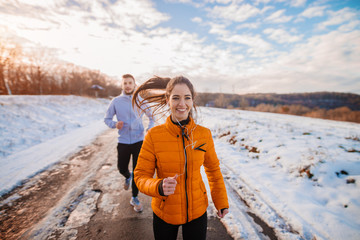 Fitness couple winter morning exercise at snowy mountain.