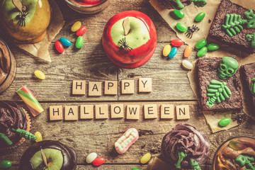 Selection of halloween party sweets - brownie, caramel apples, cupcakes, chocolate mousse, candies, top view