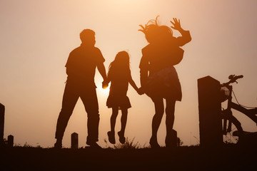 Fototapeta premium Silhouette of a family enjoying a beautiful sunset