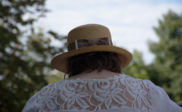 Primo piano, testa di donna con panama e maglia di pizzo,  ripresa di spalle