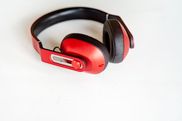 Red headphones on a white-grey background. Photo with small noise and soft similar focus.