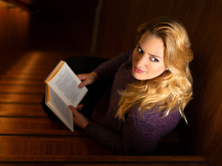 woman looking up from reading a book