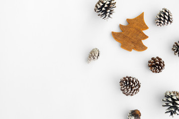 Christmas tree and pine cones on white paper, border composition. Creative flat lay, top view design