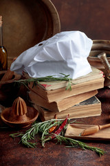 White chef's hat and old cookbooks.