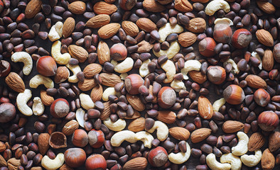 Different nuts on a wooden table. Cedar, cashew, hazelnut, walnu