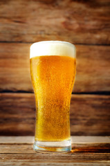 Glass of cold light beer on a wood  background