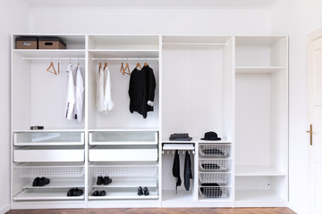 clothes hanging on rail in white wardrobe
