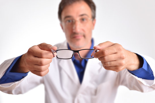 Doctor putting glasses on patient
