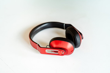 Red headphones on a white-grey background. Photo with small noise and soft similar focus.