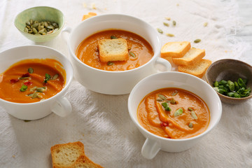 Three plates of pumpkin cream-soup with croutons