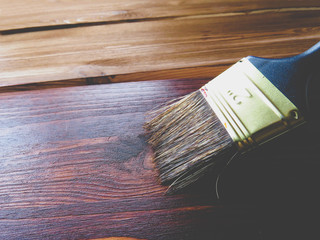 Brush on wooden background. Board half painted. painting of wooden yellow boards in brown color