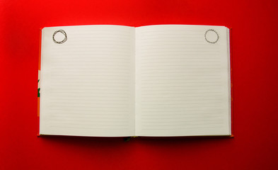 open blank notepad on red background with copy space