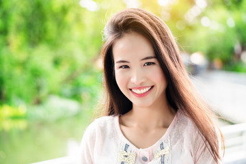 Asian teenage girl with long hair that is well maintained. Skin looks beautiful. Have a bright smile. She takes care of her teeth and mouth. So make confident Not in the state of depression.