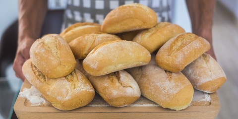 close up of pair of human hands show and offer a lot of bread produced from a bakery and a baker. fresh and freshness feeling with healthy food with natural ngredients. shop and business concept