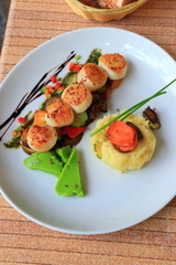 Plate of scallops cooked with its vegetables garnish in a french gastronomic restaurant
