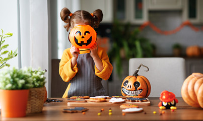 Fototapeta premium happy child girl in costumes of pumpkins are preparing for holiday Halloween.