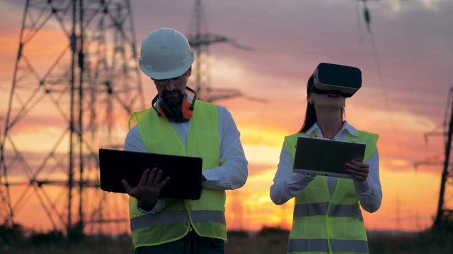 Two electricians using modern 3D virtual reality glasses for engineering in augmented reality.