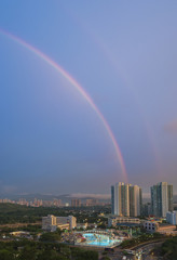 Rainbow over residential district in Hong Kong city at dusk